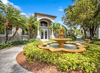 A yellow fountain is in the middle of a landscaped area.