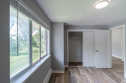 an empty room with a large window and a white door