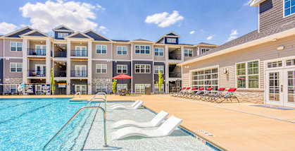 A large swimming pool in front of apartment buildings.