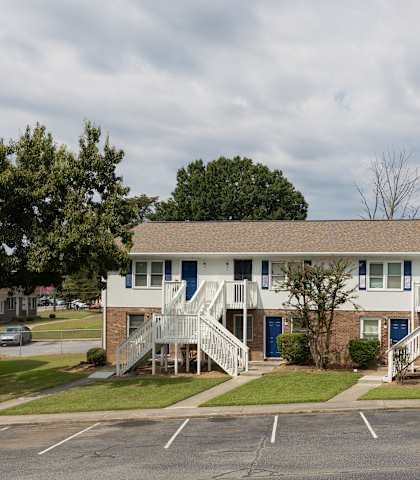 A two-story building with a car parked in front.