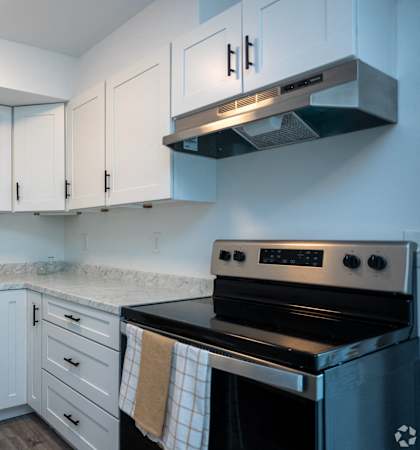 a kitchen with white cabinets and black appliances and a sink