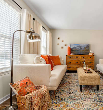 A living room with a white couch, a coffee table, and a painting on the wall.