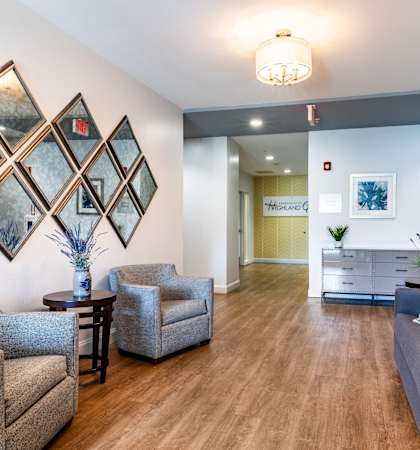 a living room with couches and chairs and a hallway to a kitchen