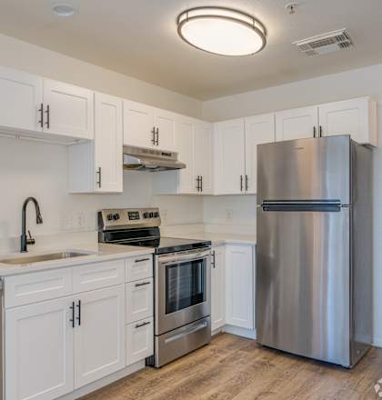 a kitchen with white cabinets and stainless steel appliances