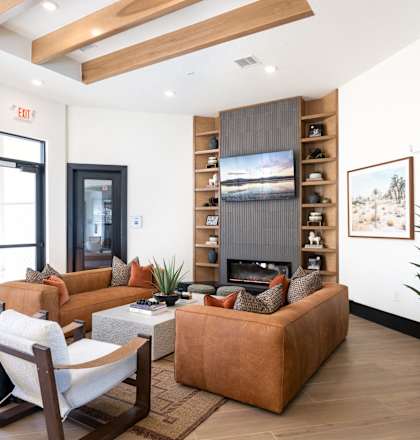 A living room with a brown couch and a fireplace.