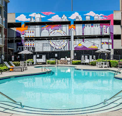 a swimming pool in front of a building with a mural on it