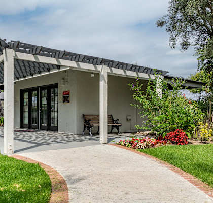A house with a covered patio and a walkway leading to it.