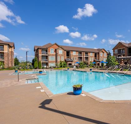 a swimming pool with an apartment building in the background