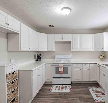 a kitchen with white cabinets and a sink and a stove at Fay Street Apartments, Winchester