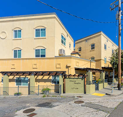 A yellow building with a sign that reads "Almonds" is located on a street corner.
