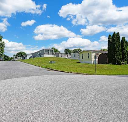 A residential street with houses on both sides and a clear sky.
