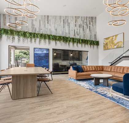 A modern living room with a wooden table and blue chairs.
