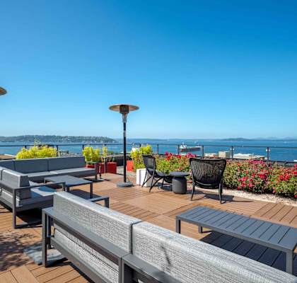 a deck with tables and chairs overlooking the ocean