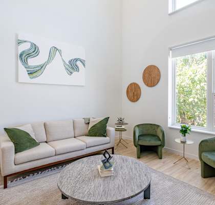 a living room with a couch and chairs and a coffee table