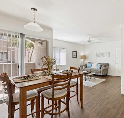 A dining room with a table set for six with a view of the outside.