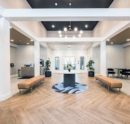 A spacious lobby with a wooden floor and white columns.