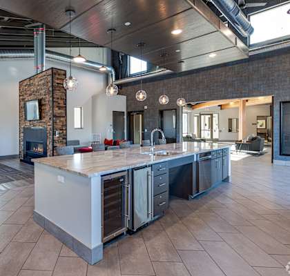 A modern kitchen with a large island and a brick chimney.