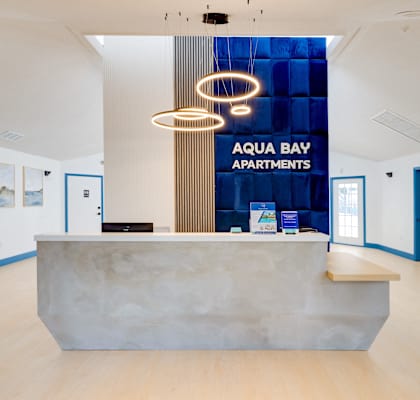 a reception area with a marble desk and a blue sign on the wall