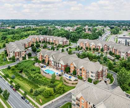 A bird's eye view of a residential area with houses and a swimming pool.