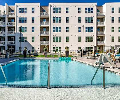 A swimming pool in front of apartment buildings.