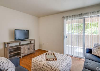 a living room with a tv and a sliding glass door