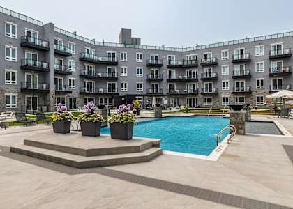 A large apartment complex with a pool and a patio area.