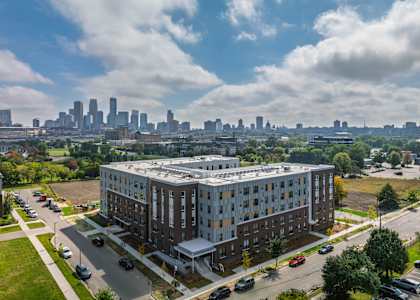 A large apartment building with a parking lot in front of it.