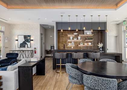 A modern dining room with a black table and blue chairs.