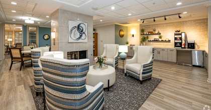 a lobby with chairs and a table and a fireplace
