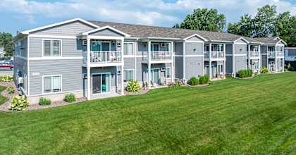 the view of an apartment building with a green lawn