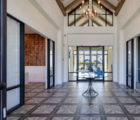 A large open hallway with a chandelier and a table in the middle.at Imperial Crossing Luxury Apartment Homes, Bonita Springs, FL, 34134
