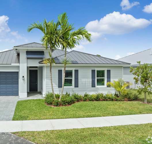 a white house with a palm tree in front of it