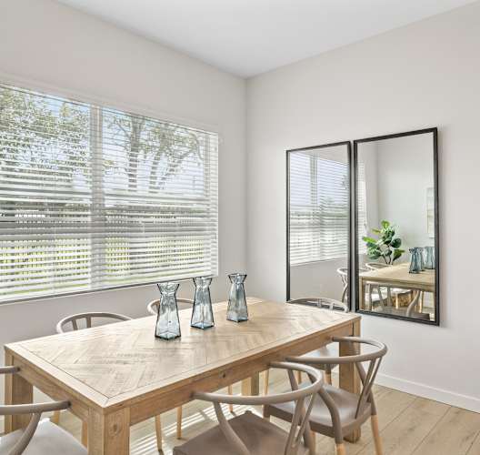 a dining room with a table and chairs and a large window