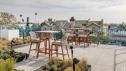 A patio with a table and chairs overlooking a street.