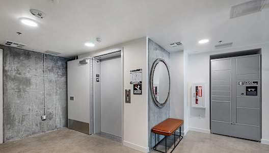 A room with a bench, a mirror, and a fire extinguisher.