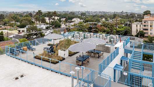 A rooftop patio with a striped awning and a staircase.