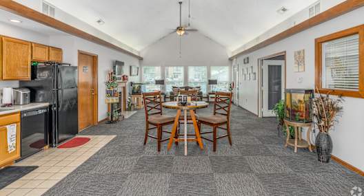 A kitchen with a dining table and chairs in the middle of the room.