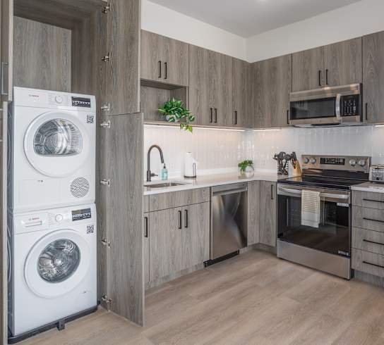 A modern kitchen with a washing machine built into the cabinetry.