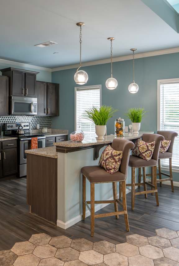 a kitchen with stainless steel appliances and a bar with chairs