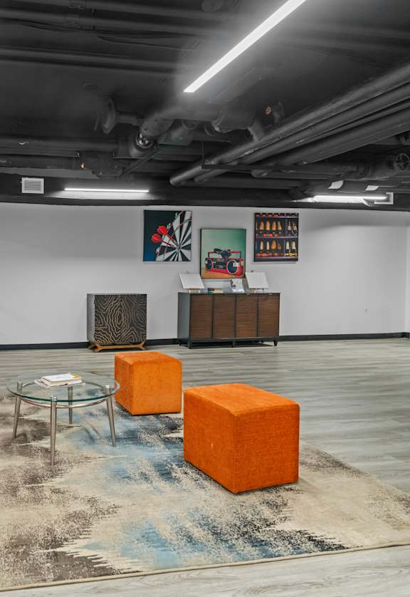 Orange chairs are arranged in a row in a room with a rug on the floor.