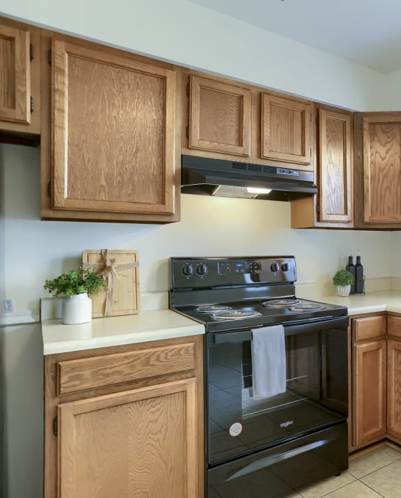 a kitchen with wooden cabinets and black appliances