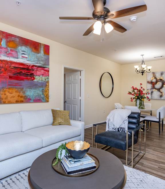 A modern living room with a stone fireplace and a large open space at Waterleaf at Neely Ferry Apartments, Simpsonville, SC
