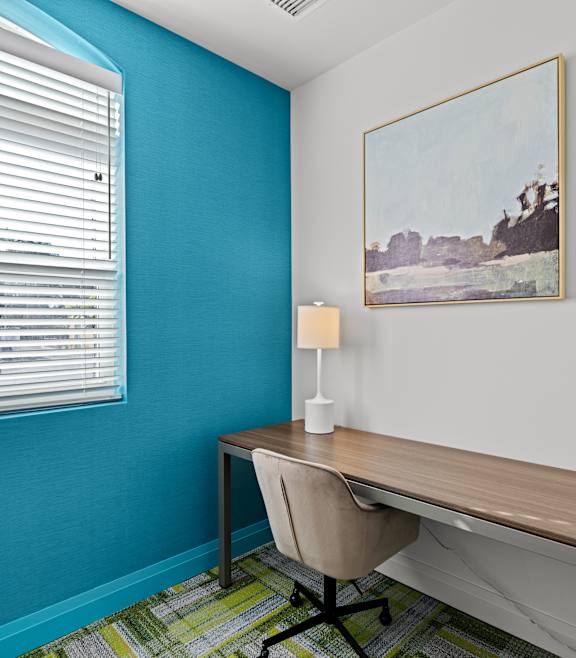 A kitchen with a blue wall and wooden floors.