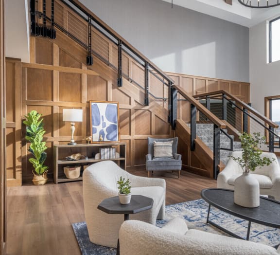 a living room with a staircase and a rug