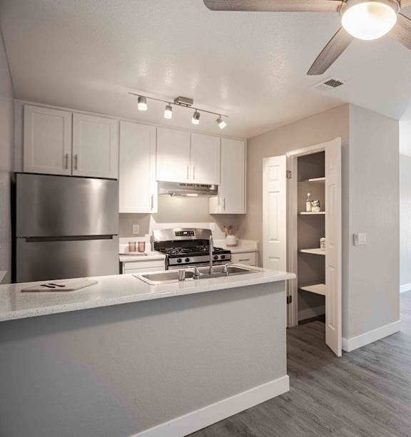 an open kitchen and living room with a ceiling fan