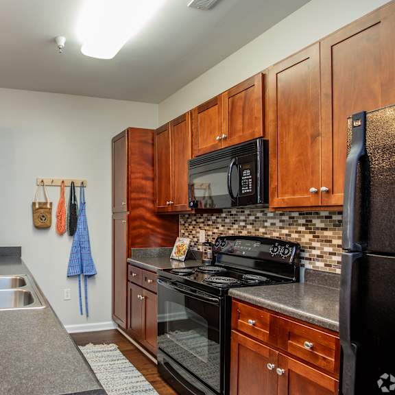 A kitchen with wooden cabinets and black appliances.