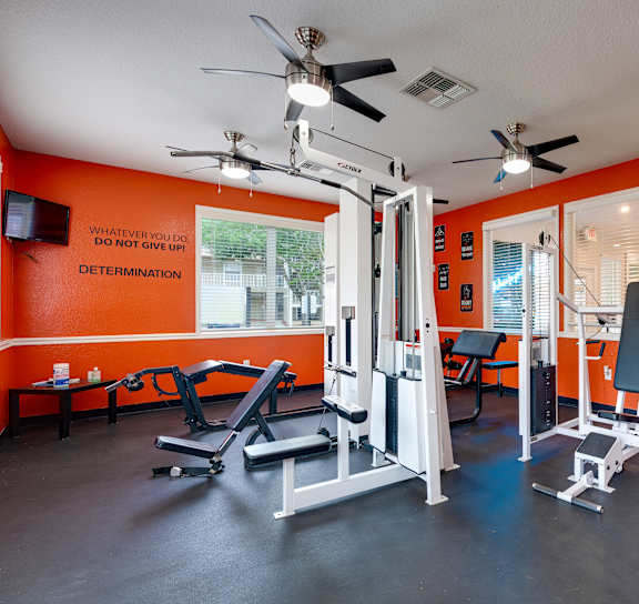 a workout room with red walls and exercise equipment