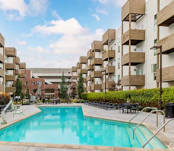 A swimming pool in front of apartment buildings.
