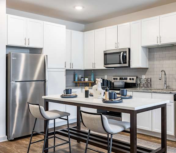 A modern kitchen with a table and chairs.
