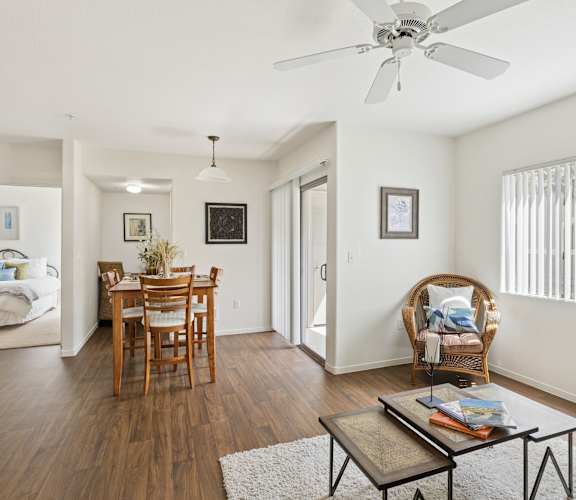 A living room with a wooden floor and a ceiling fan.